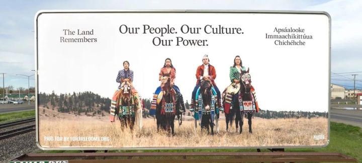 Photo by Nathan Stratan. A billboard titled “The Land Remembers” by artists JoRee LaFrance, Bethany Yellowtail, Elan Creative