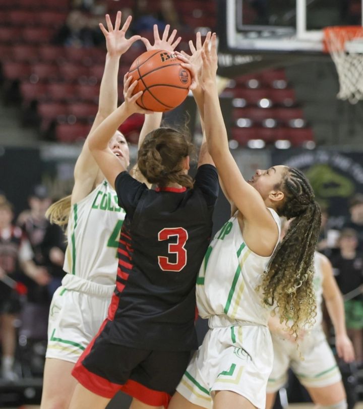 Malea Egan (left) and Gracie Bradley trap Huntley’s Paige Lofing. / Photo by Tommy B. Robinson